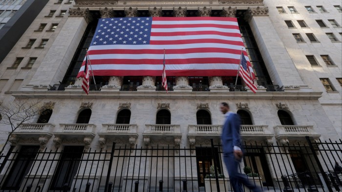 A large US flag hangs on the facade of the New York Stock Exchange building.